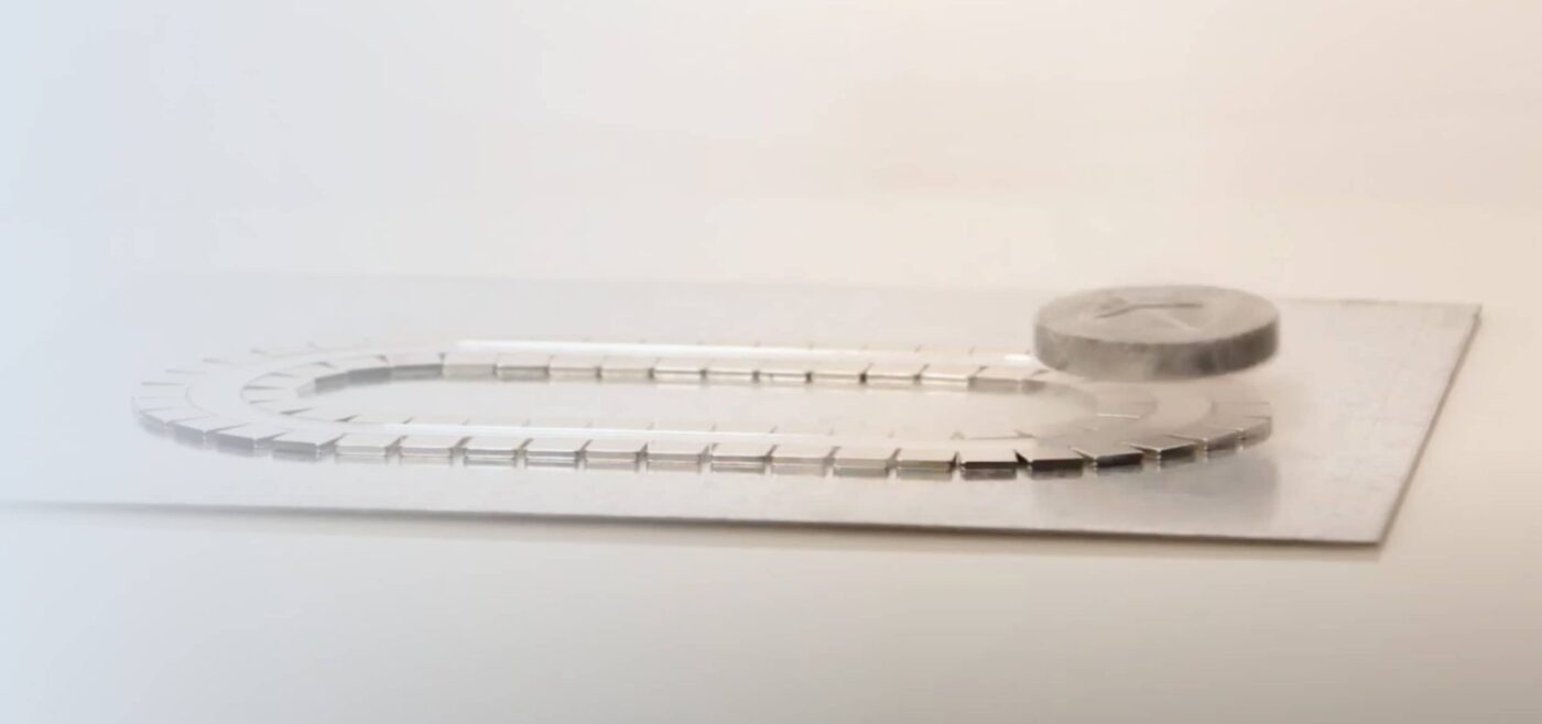 A thin-film Quantum Levitator locked above a track of neodymium magnets, free to glide along the track