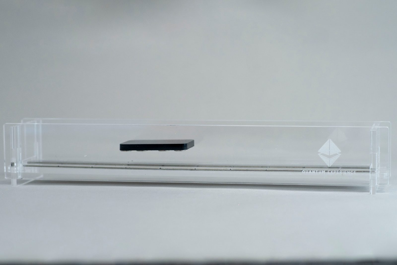 Side view of the carriage floating above the magnet rail with clear Perspex guide walls on either side holding it in the channel